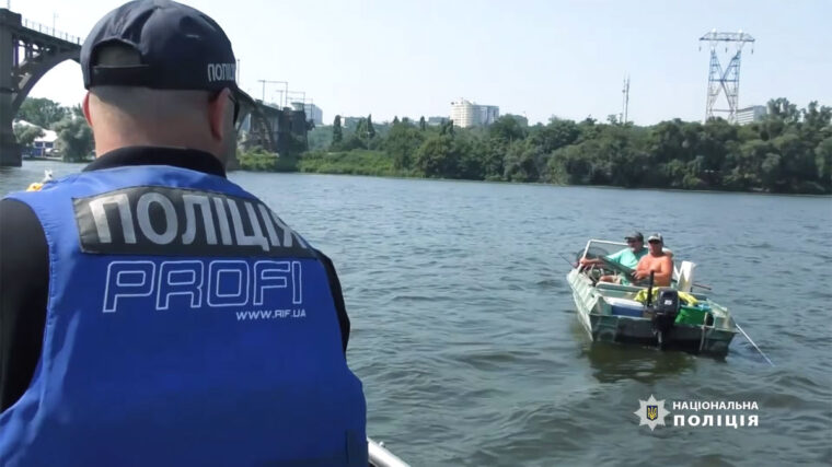 Проверка документов водной полицией у рыболова на моторной лодке на Днепре